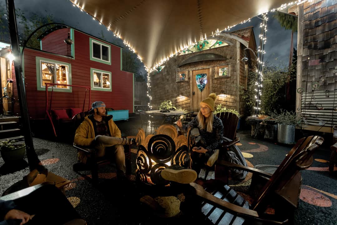 Toasting s'mores over a campfire outside tiny houses in Portland Oregon USA