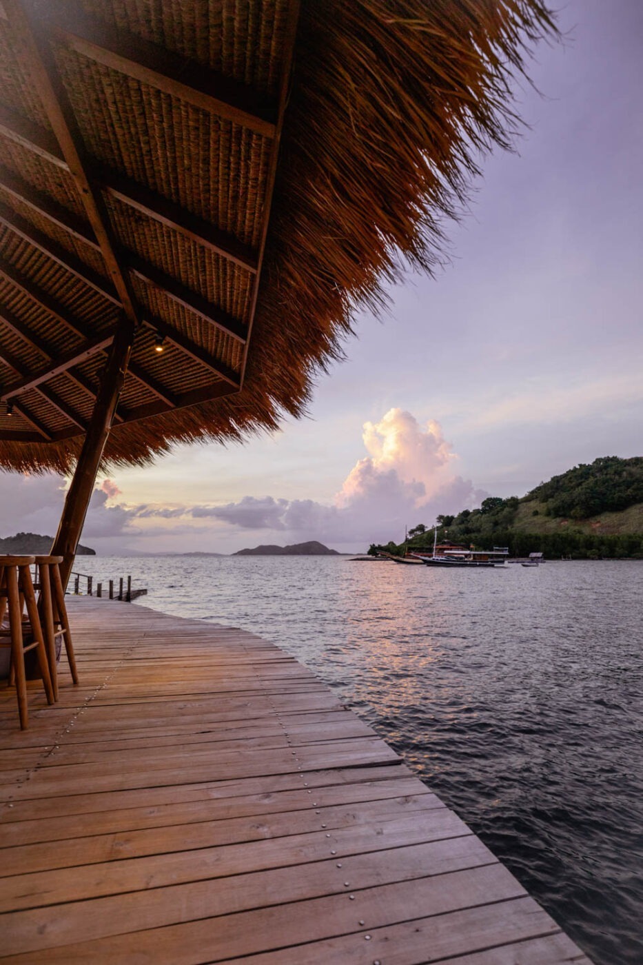 Sunset behind a 360-degree bar at the end of a wooden boardwalk