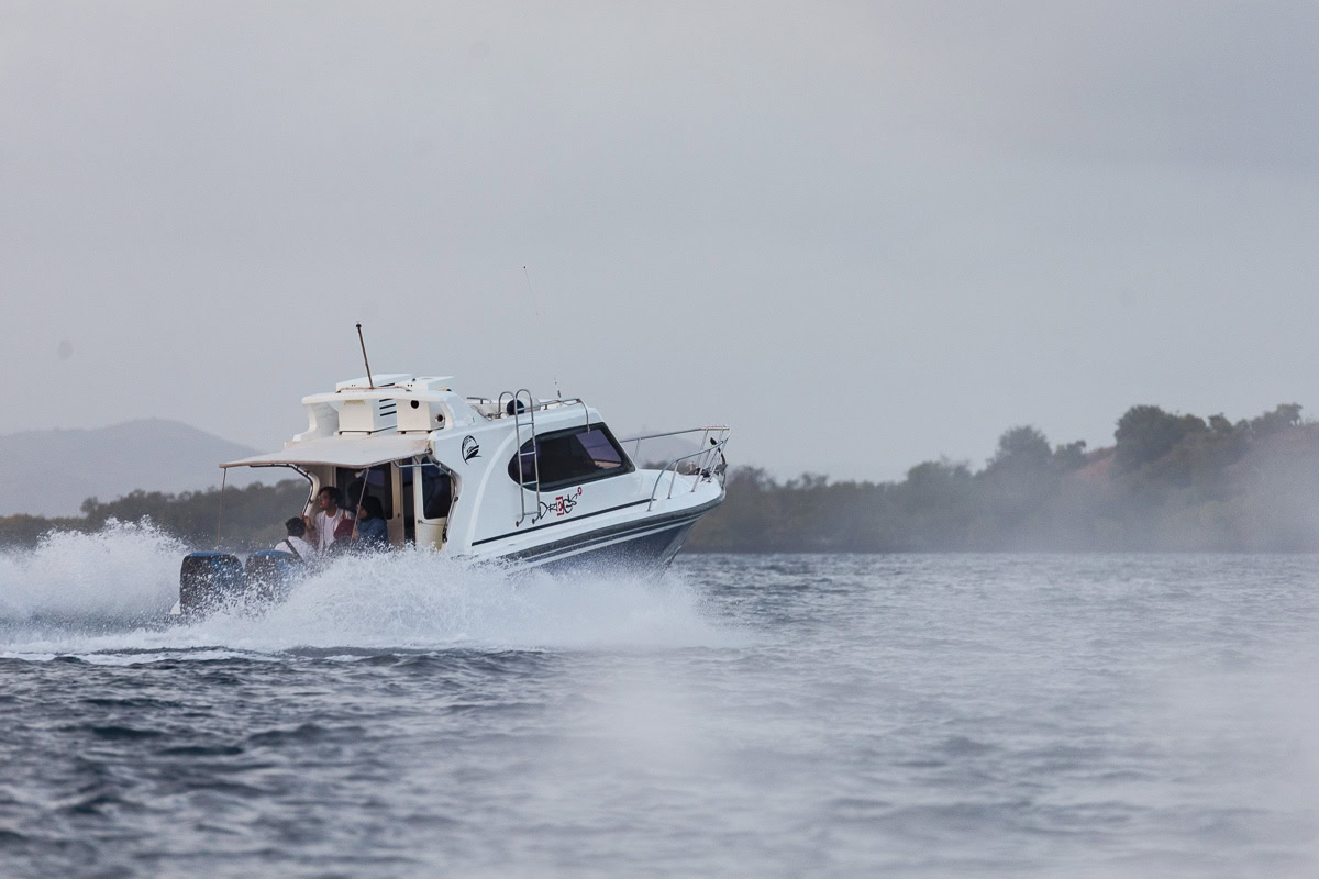 Planning A Komodo Island Day Trip: Tips & Warnings For Booking A Boat Tour Of Komodo Island, Indonesia 5 A Komodo day trip speedboat racing through the water at high speed, with water splashing away.