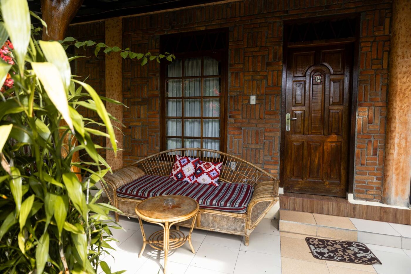 A Unique Stay At Tabo Cottages, Samosir Island: A Lake Toba hotel with a story 7 Balcony with a sofa and table in a Deluxe room at Tabo Cottages