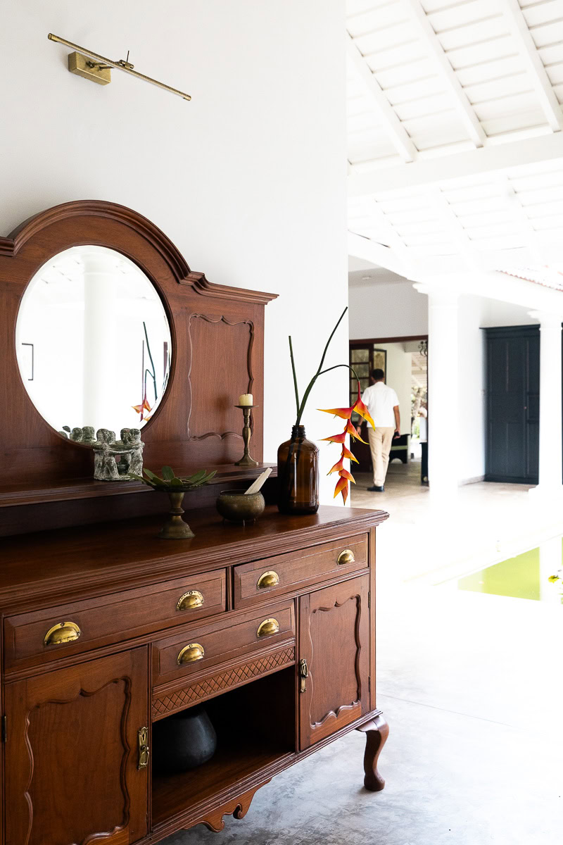 Uga Riva: A New Boutique Hotel In Negombo With A 180-Year History 28 An antigue cabinet at the entrance of Uga Riva, with a staff member walking through an archway in the background