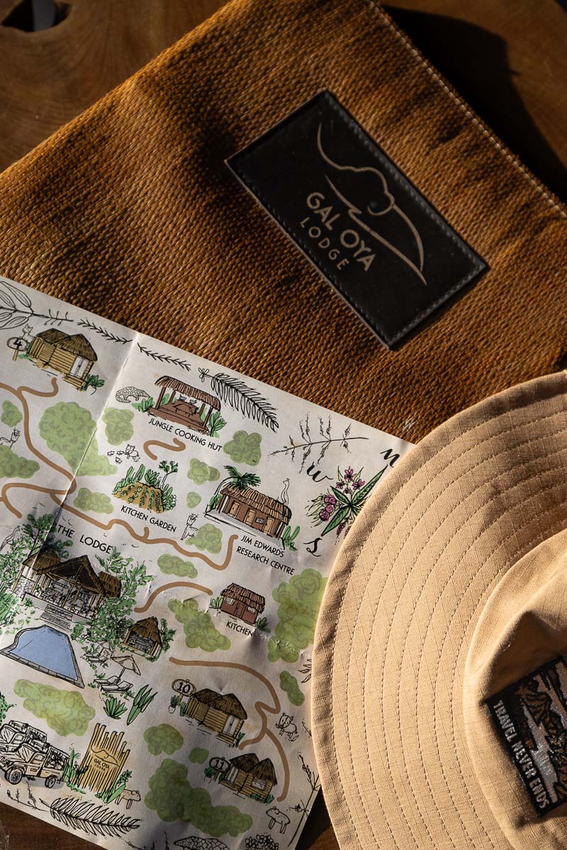 Gal Oya Lodge: A Luxury Eco Lodge In Sri Lanka's Least Visited National Park 4 A map of Gal Oya Lodge sits open on a table next to a wooden dossier with Gal Oya Lodge written on it and a safari hat