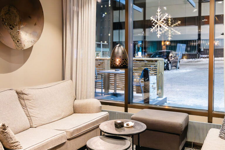 Header for Lapland Hotels Kuopio review showing seating area with snowflake light in the window and snow outside