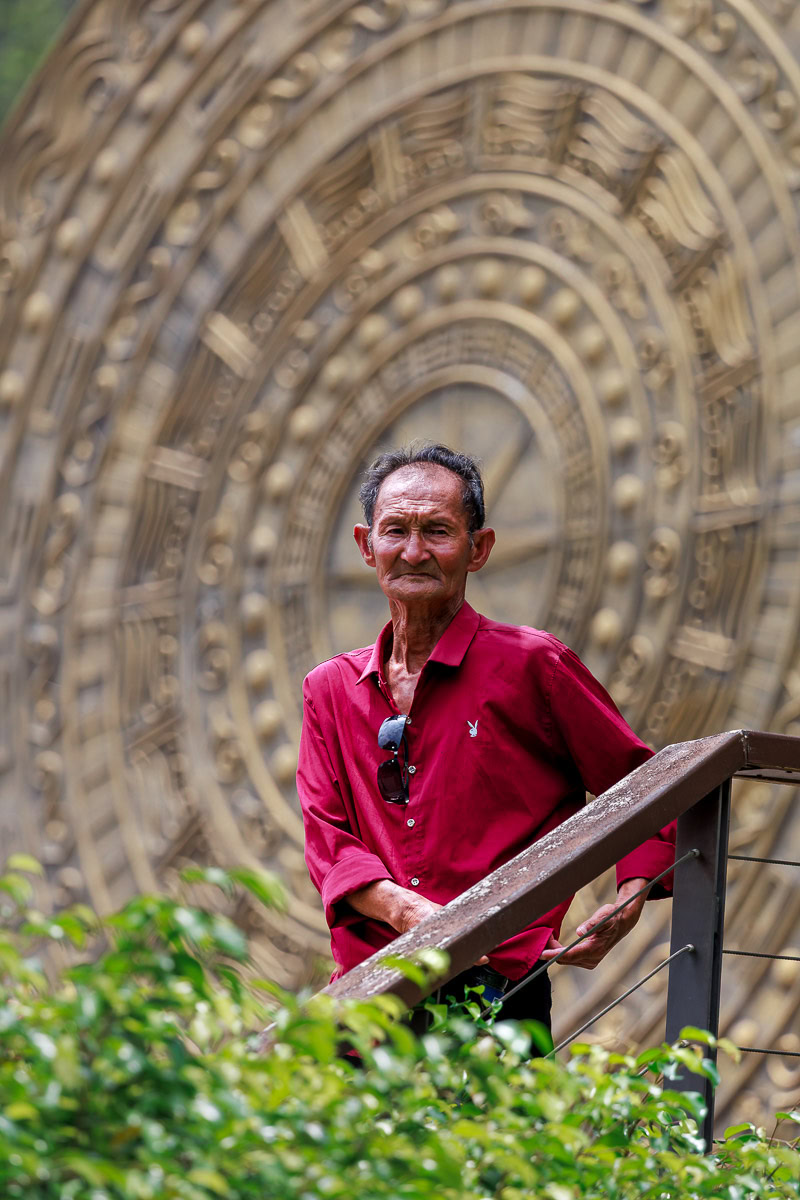 A Chinese man standing in front of a monument at Detian Falls